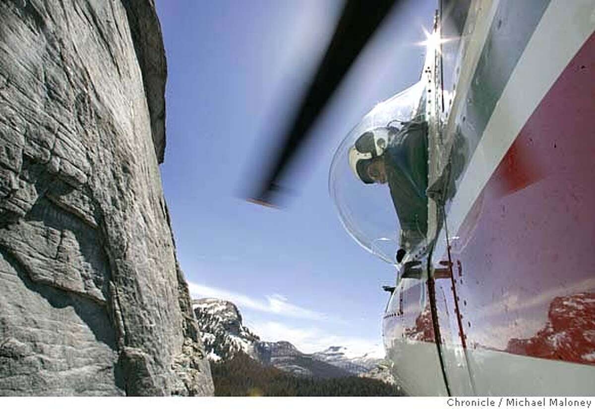 Helicopter pilot David Boden looks out his bubble window as he maneuvers close to the massive granite wall of Fairview Dome lowering a SAR member to a ledge on the cliff face. Members of Yosemite National Park�s Search and Rescue Team (SAR) participate in "short-haul" training - using a helicopter to haul a SAR member on the end of a 150 foot rope to rescue stranded or injured climbers or hikers. Members of SAR are required to re-certify every 90 days for short haul rescue. On this day, they practiced short haul on Fairview Dome in the Tuolumne meadows area of Yosemite Every year, the park�s Search and Rescue team deals with over 200 incidents and the park has, on average, about 12 fatalities per year. At least 10-14 short haul type rescues take place each year. Those can range from taking a climber off of El Cap to hauling out an injured backcountry hiker. Their helicopters log over 350 hours in the air every season. Photo by Michael Maloney / San Francisco Chronicle ***David Boden MANDATORY CREDIT FOR PHOTOG AND SF CHRONICLE/NO SALES-MAGS OUT