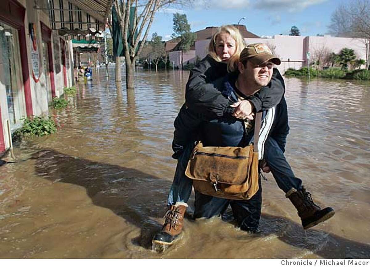 Sandy Nugent of Napa, Ca. is carried to saftey by her son Scott, affter they checked on the condition of their downtown business. About 3 feet of water filled the downtown Napa Valley Dance Center, which they have owned for the past 18 years. The Bay Area woke this morning to major flooding in several neighborhoods throughout the Bay Area. Event in Napa, Ca on 12/31/05. Photo by: Michael Macor / San Francisco Chronicle