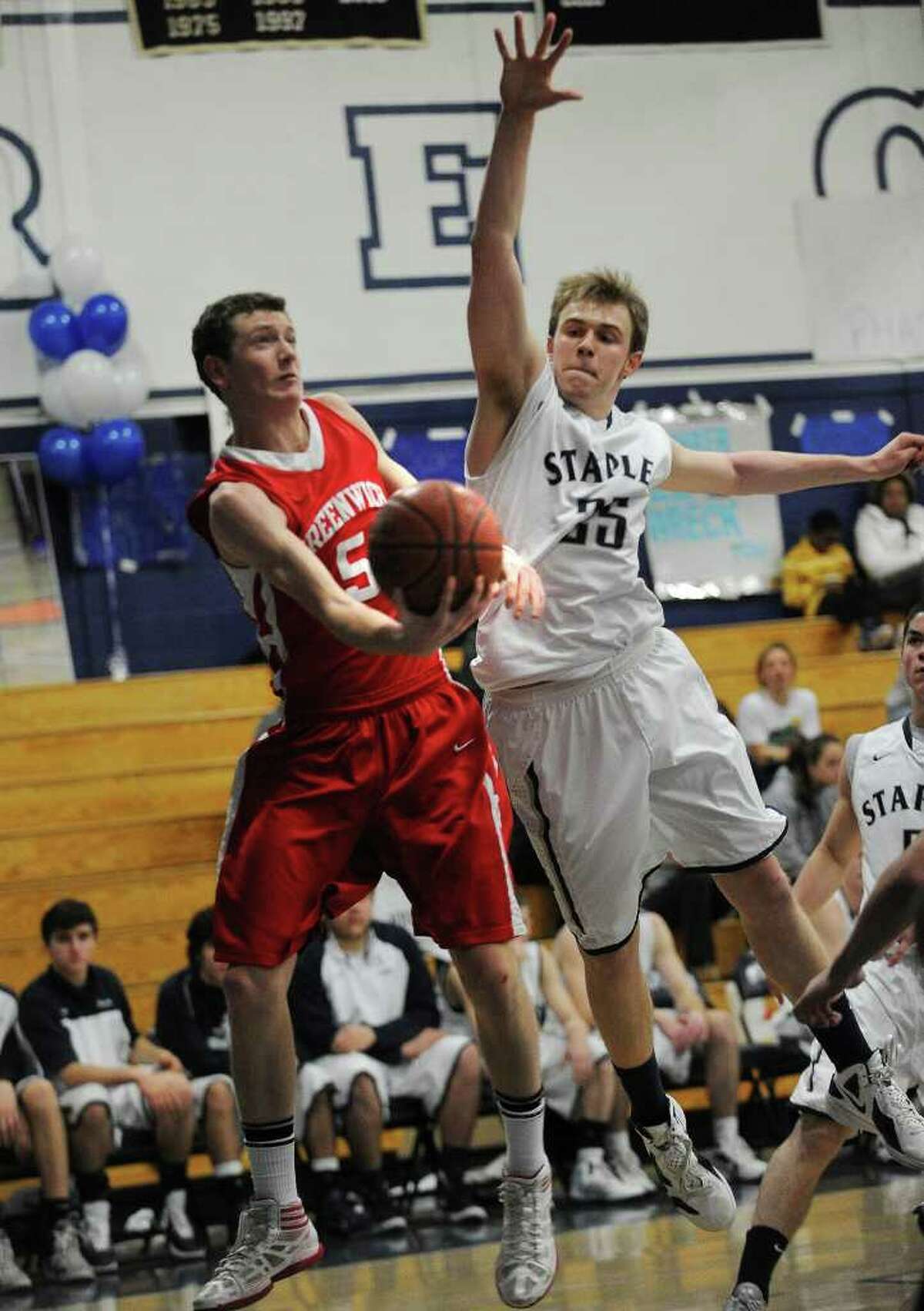 Greenwich's Jonathan Palmer attempts a finger roll in front of Staples defender Michael Argosh during their FCIAC matchup at Staples High School in Westport on Monday, February 13, 2012.