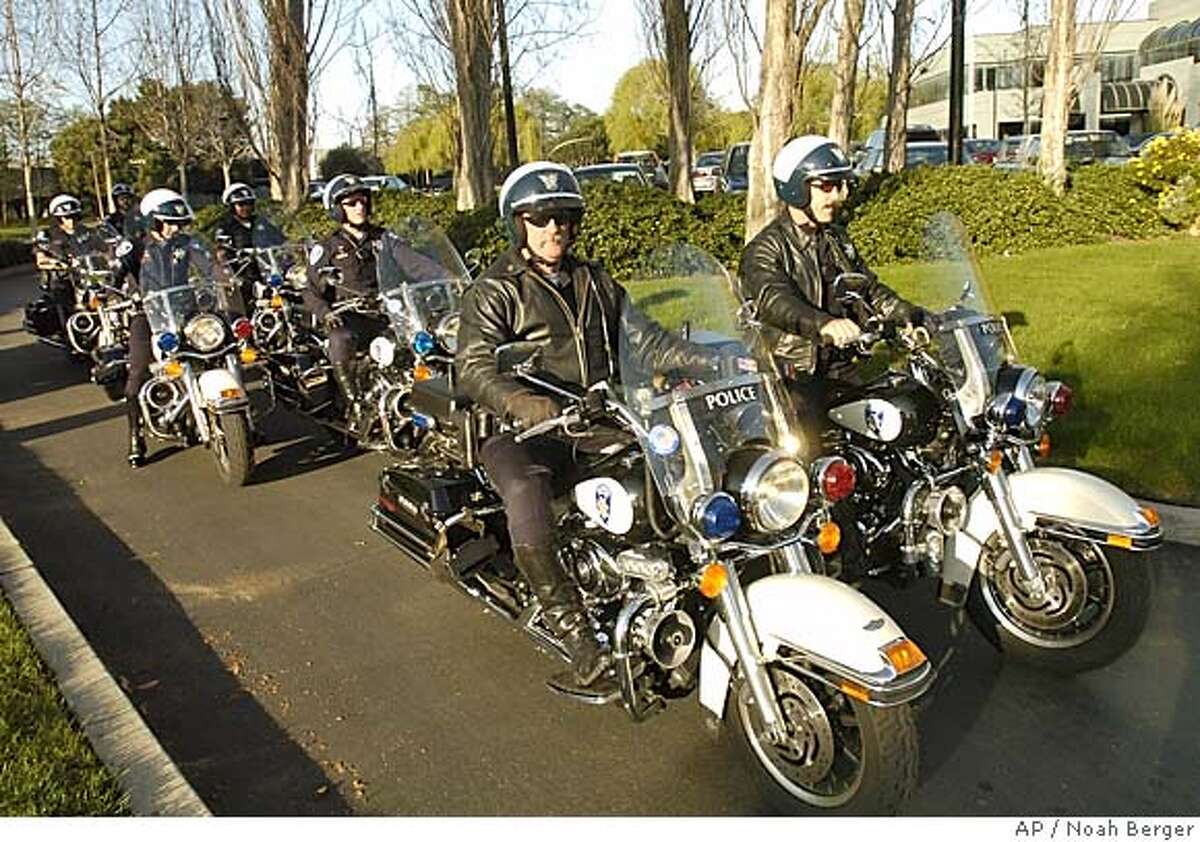 Alameda police officers wait to provide an escort for wide receiver Randy Moss from the Oakland Raiders' headquarters in Alameda, Calif., to the airport on Wednesday, Mar. 2, 2005. Moss attended a news conference at which the Raiders announced he will join the team. (AP Photo/Noah Berger)