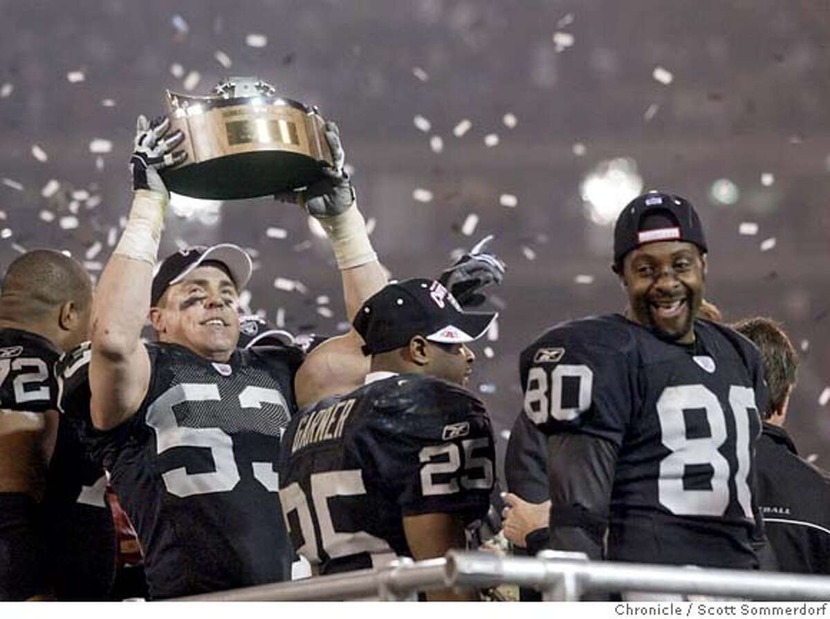 OAKLAND2-c-19JAN03-SP-SS LB Bill Romanowski raises the AFC trophy as Charlie Garner (center; 25) and Jerry Rice (R;80) revel in their AFC title game win over Tennessee. (SF CHRONICLE PHOTO BY SCOTT SOMMERDORF)