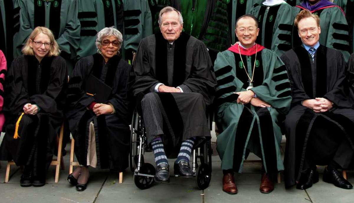 Former U.S. President George HW Bush( center) poses for a photograph with Dartmouth College President Jim Yong Kim, comedian Conan O'Brien and others at the Dartmouth commencement ceremonies last June.