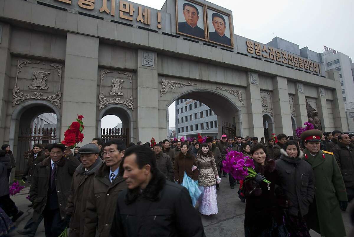 North Koreans leave the grounds of the Mansudae Art Studio in Pyongyang after watching the unveiling of a new bronze statue depicting the late leader Kim Jong Il and his father Kim Il Sung on Tuesday, Feb. 14, 2012. As North Koreans prepare for what would have been the 70th birthday of late leader Kim Jong Il this week, the country's state media have gone to great lengths to build up the man who led the nation for 17 years until his death in December. (AP Photo/David Guttenfelder)