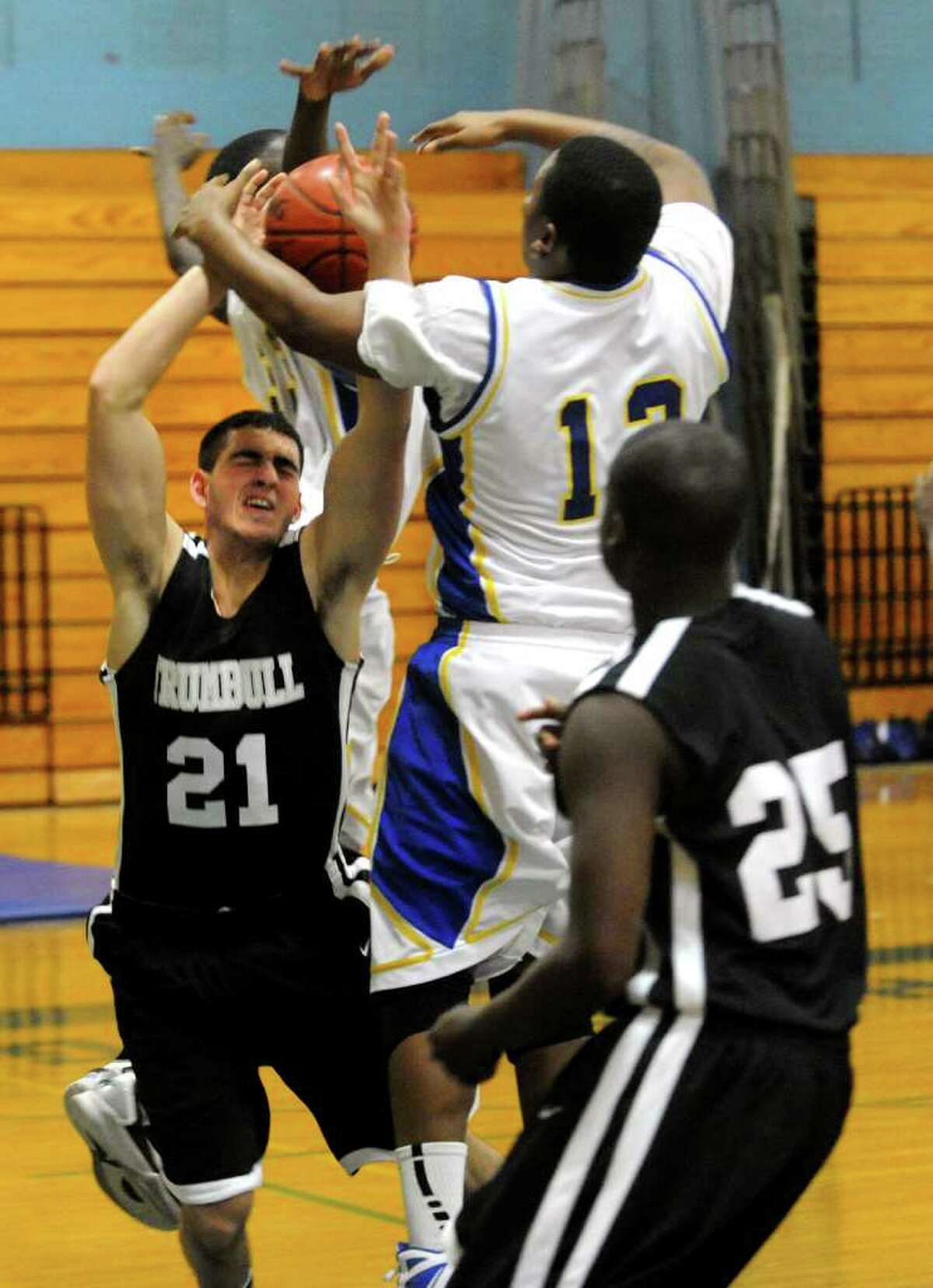 Harding's #12 Kayron Chappell, right, shuts down a shot attempt by Trumbull's #21 Tyler Paolini, during boys basketball action in Bridgeport, Conn. on Wednesday February 15, 2012.