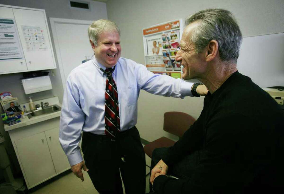 General practitioner Steven Saunders, M.D., left, meets with Daniel Benedetti of Milford, a patient for twenty years, at his practice at 1 Golden Hill Street in Milford on Thursday, February 16, 2012.