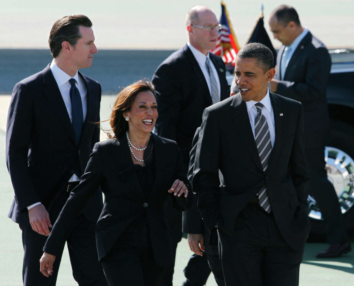 President Obama walks with state Attorney General Kamala Harris and Lt. Gov. Gavin Newsom after his arrival aboard Air Force One at SFO in February 2012.