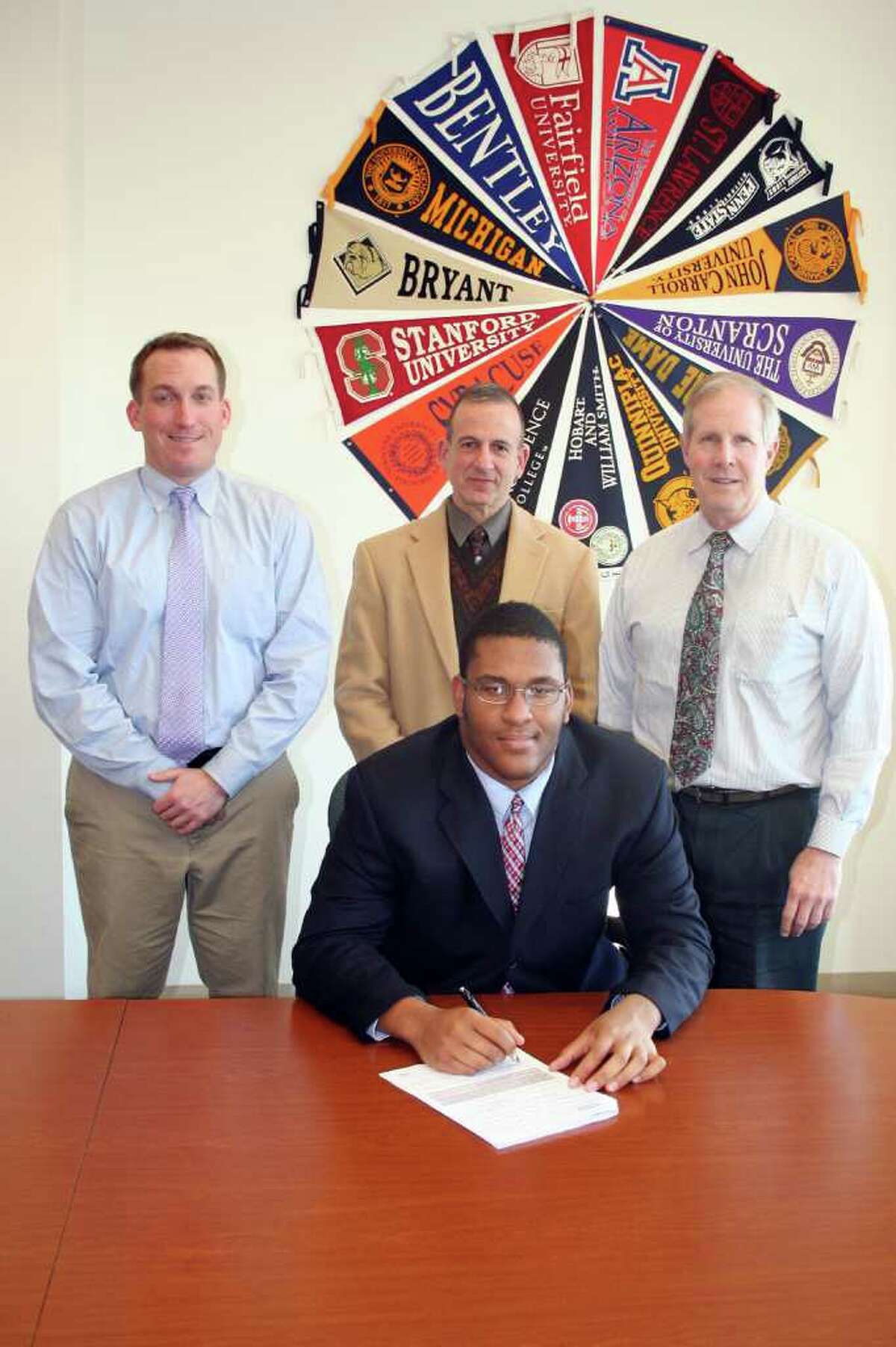 Fairfield Prep senior Serge Jean-Baptiste, of Norwalk, recently signed a National Letter of Intent to play football at Stonehill College. Pictured from left are assistant football coach Keith Hellstern, Principal Robert Perrotta, Jean-Baptiste, and head football coach Tom Shea.