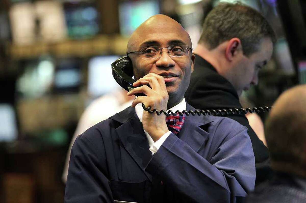 A stock trader works Friday in New York. The Dow Jones average had its highest close of the year.