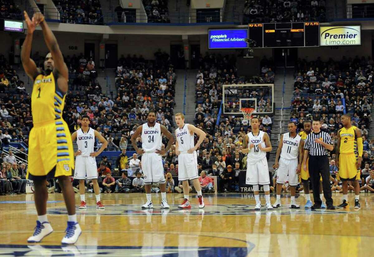 Marquette's Darius Johnson-Odom, left, shoots a basket for a technical foul called on Connecticut's Ryan Boatright (11) in the second half of an NCAA college basketball game in Hartford, Conn., Saturday, Feb. 18, 2012. Marquette won 79-64. (AP Photo/Jessica Hill)