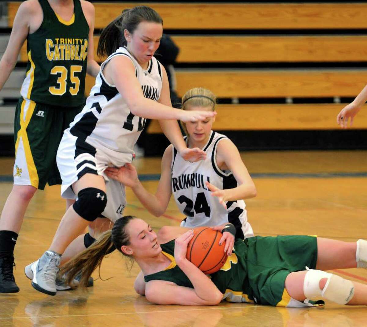 Trinity Catholic's #42 Mackenzie Griffin looks to hold onto the ball as Trumbull's #10 Kate O'Leary, left, and #24 Amanda Pfohl converge to grab it, during FCIAC Girls Basketball Quarterfinal action in Fairfield, Conn. on Saturday February 18, 2012.