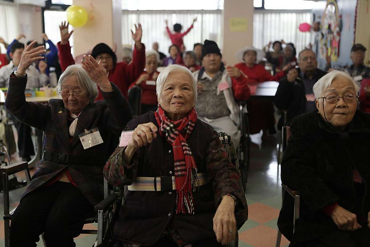 Yeung Wai Ching (center), 95, participates in a taped exercise class with others in the Day Room at the SteppingStone Mabini Day Health on Tuesday, February 14, 2012 in San Francisco, Calif.