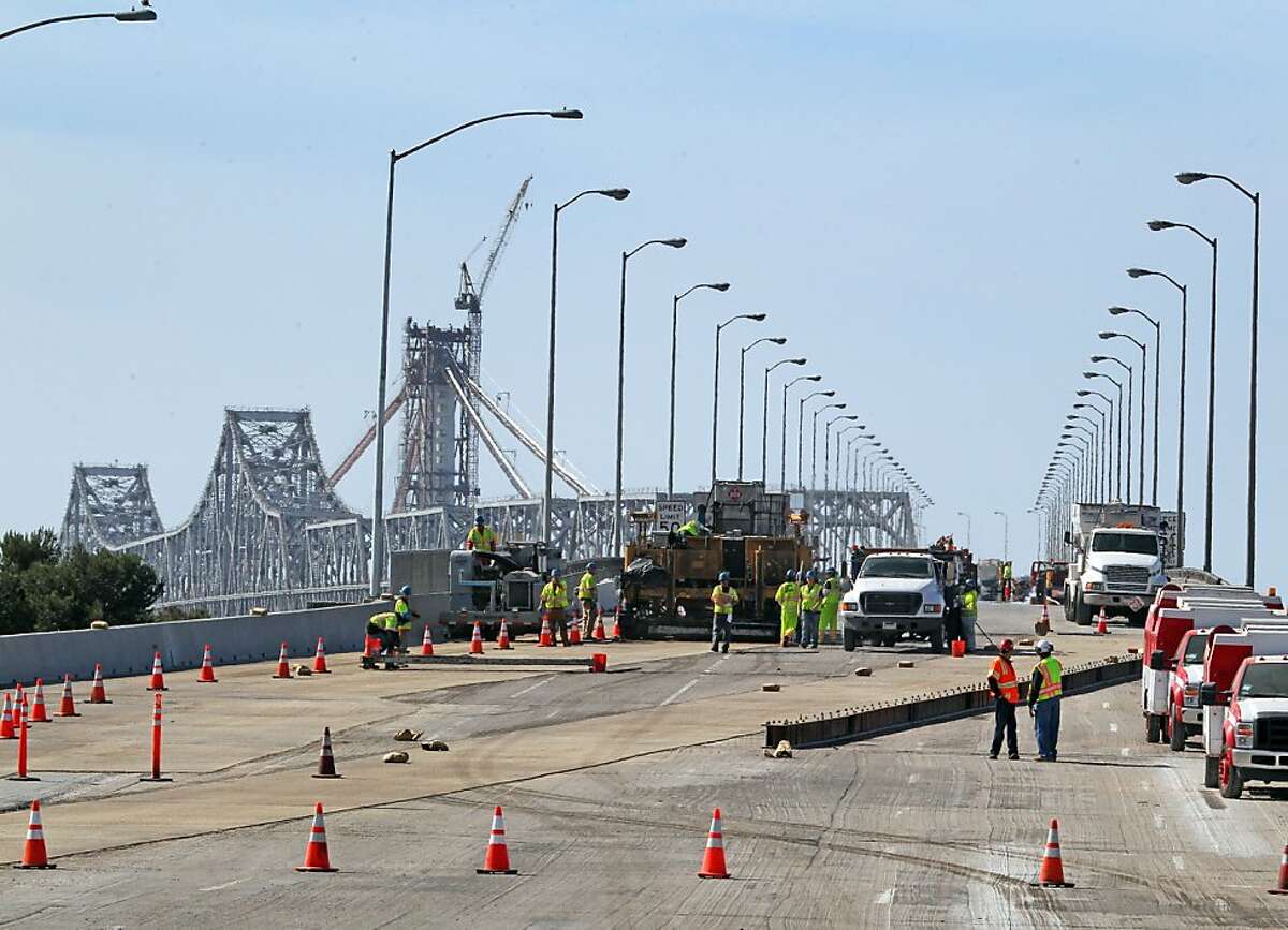 Asphalt is laid on the westbound lanes of the Bay Bridge Saturday, February 18, 2012. Caltrans is estimating that over one hundred truckloads will be delivered to the bridge over the weekend. Weather permitting, the bridge is expected to reopen early Tuesday morning.