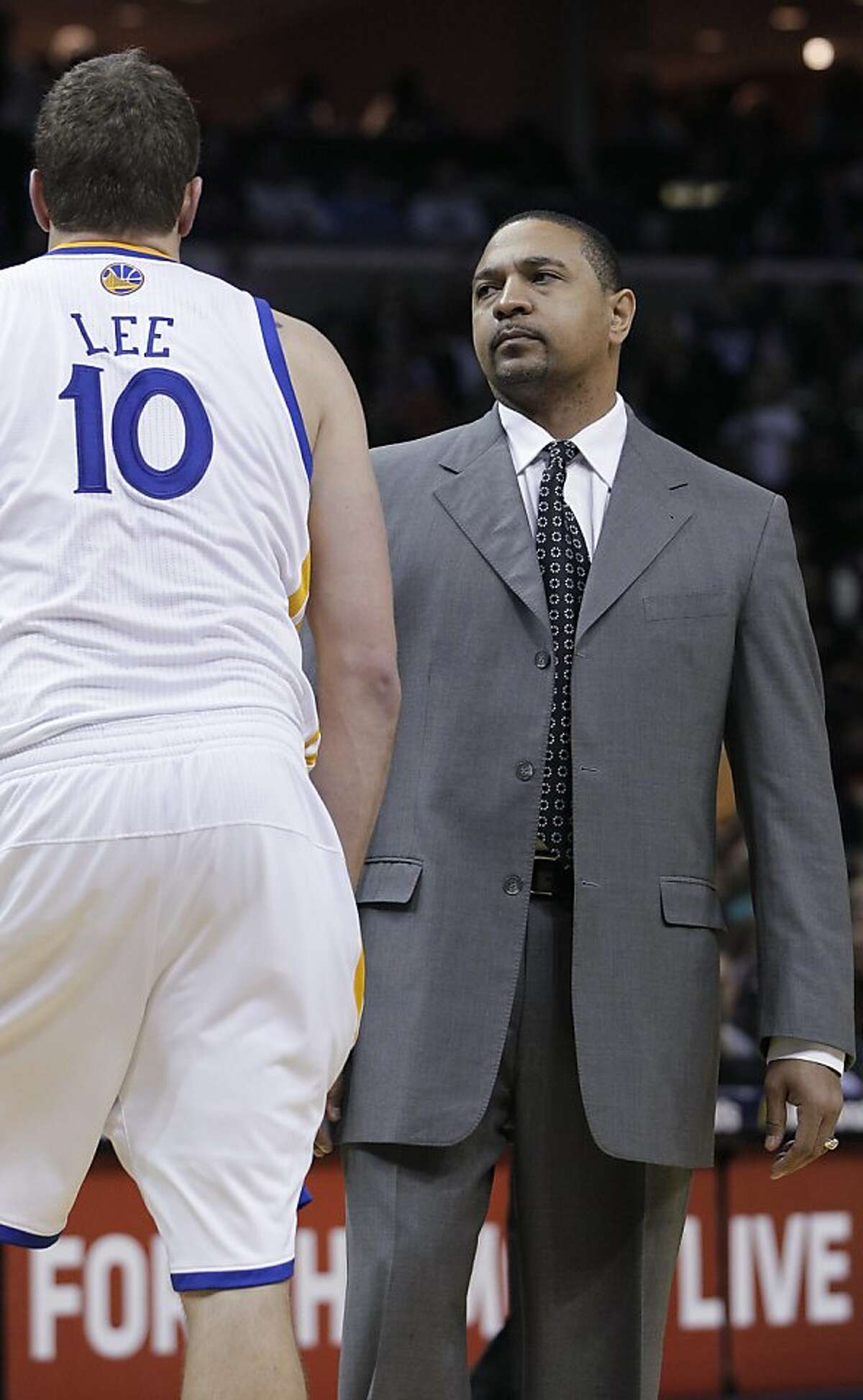 Golden State Warriors coach Mark Jackson, right, talks with forward David Lee during the second half of an NBA basketball game in Memphis, Tenn., Saturday, Feb. 18, 2012. Memphis defeated Golden State 104-103.