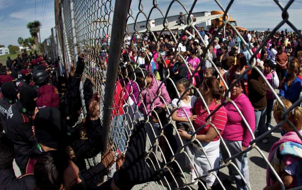 Police hold back the relatives of inmates outside the Apodaca correctional state facility as they try to get past the gates in Apodaca on the outskirts of Monterrey, Mexico, Sunday Feb. 19, 2012. A fight among inmates at the prison led to a riot that killed dozens on Sunday, according to a security official. (AP Photo/Hans Maximo Musielik)