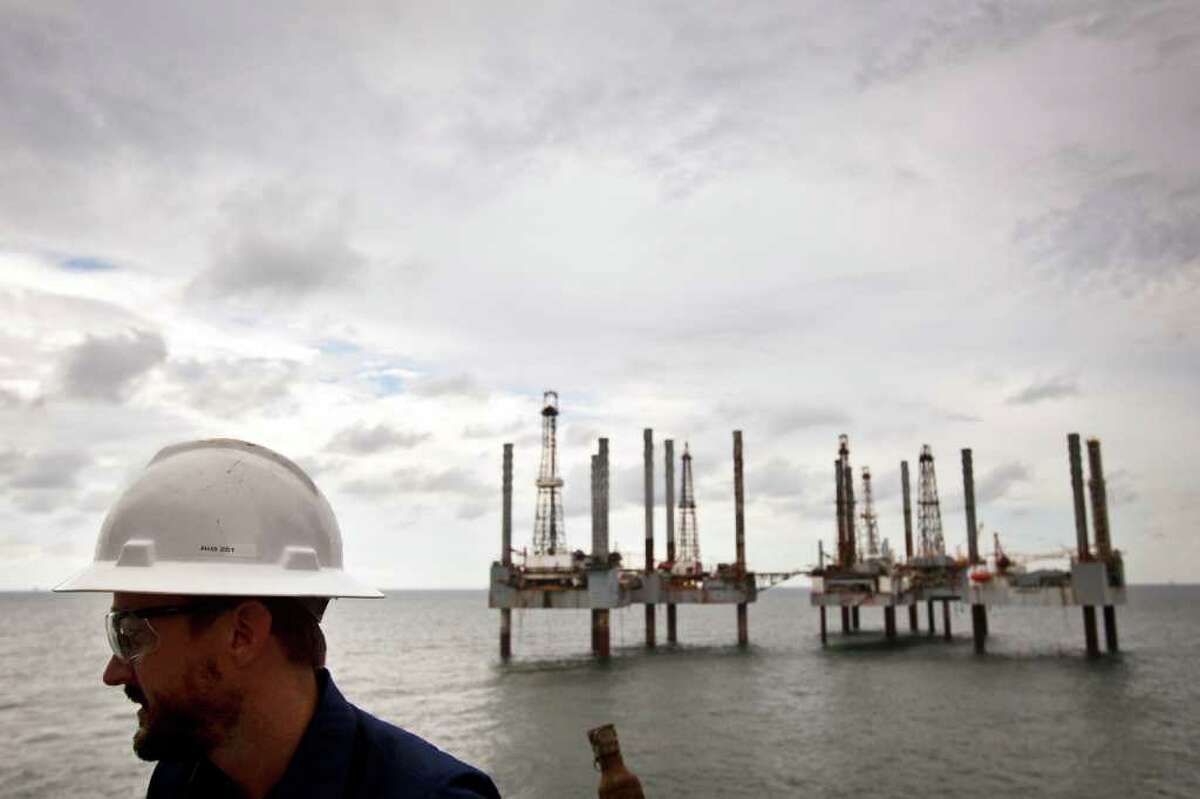 A group of idle rigs is seen behind James Noe, Senior Vice President, General Counsel and Chief Compliance Officer for Hercules Offshore while aboard the Hercules 251 a shallow water drilling rig owned by on Wednesday, Aug. 11, 2010, near Port Fourchon, La.. While shallow offshore drilling is not subject to a federal moratorium, Hercules officials say only two permits have been issued since June, idling activity in their fleet. The company has about 250 employees on idle rigs, with each rig costing the company about $25,000 per day to operate while generating no revenue for the company.( Smiley N. Pool / Chronicle )