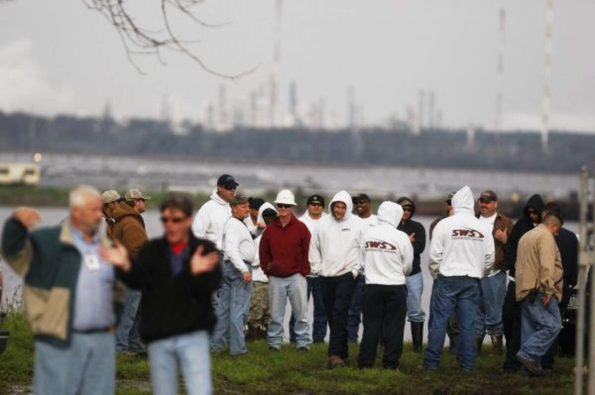 Hazardous spill cleanup crews stand next to the San Jacinto River to help contain and clean up a chemical spill created at a location operated by ZXP Technologies after it was reported yesterday that there was an oily residue in a nearby canal. (Johnny Hanson / Houston Chronicle)