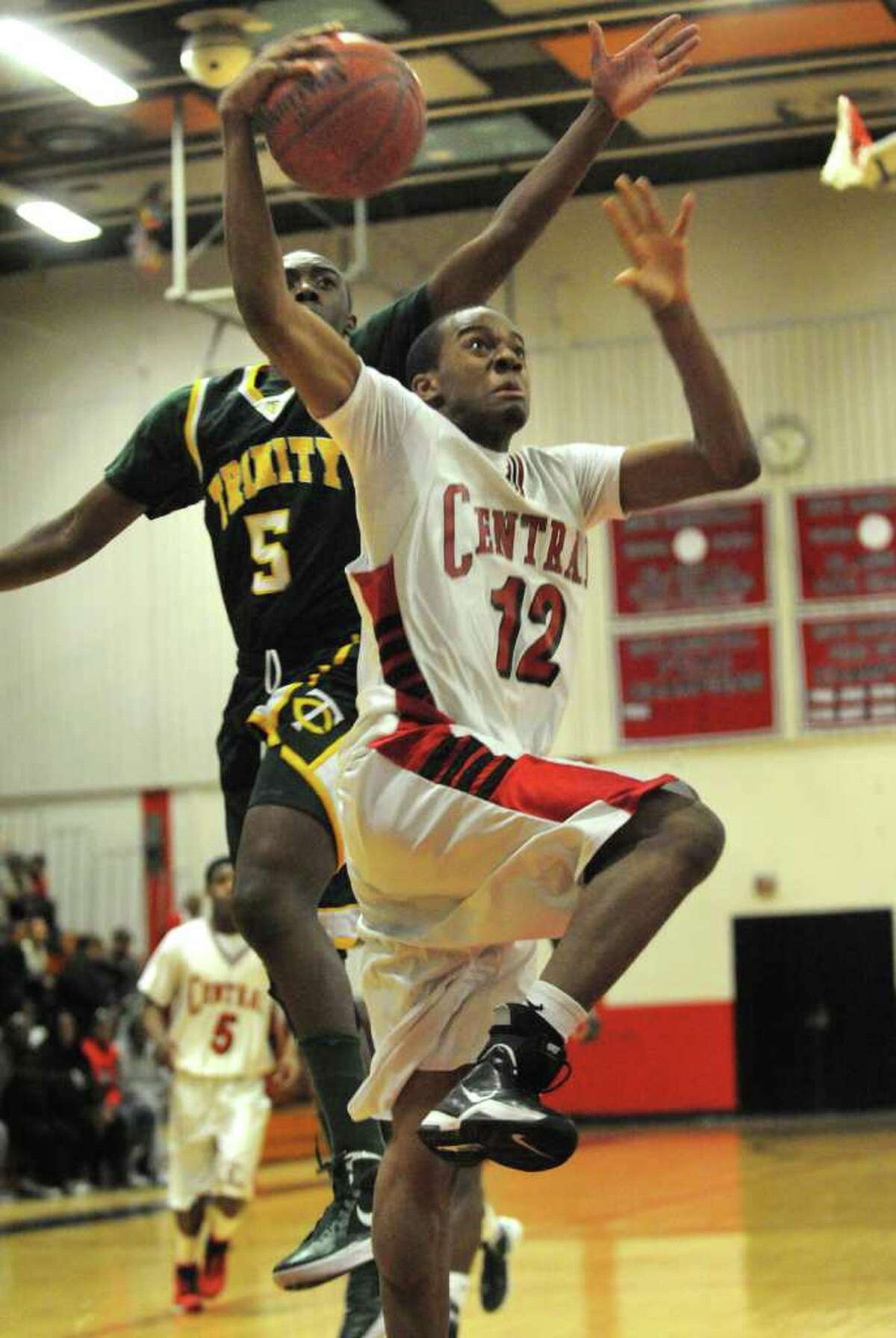 Trinity Catholic's Brandon Wheeler, left, looks for the block as Central's Josh Wilkerson drives to the basket during their FCIAC matchup at Central High School in Bridgeport on Monday, February 20, 2012.