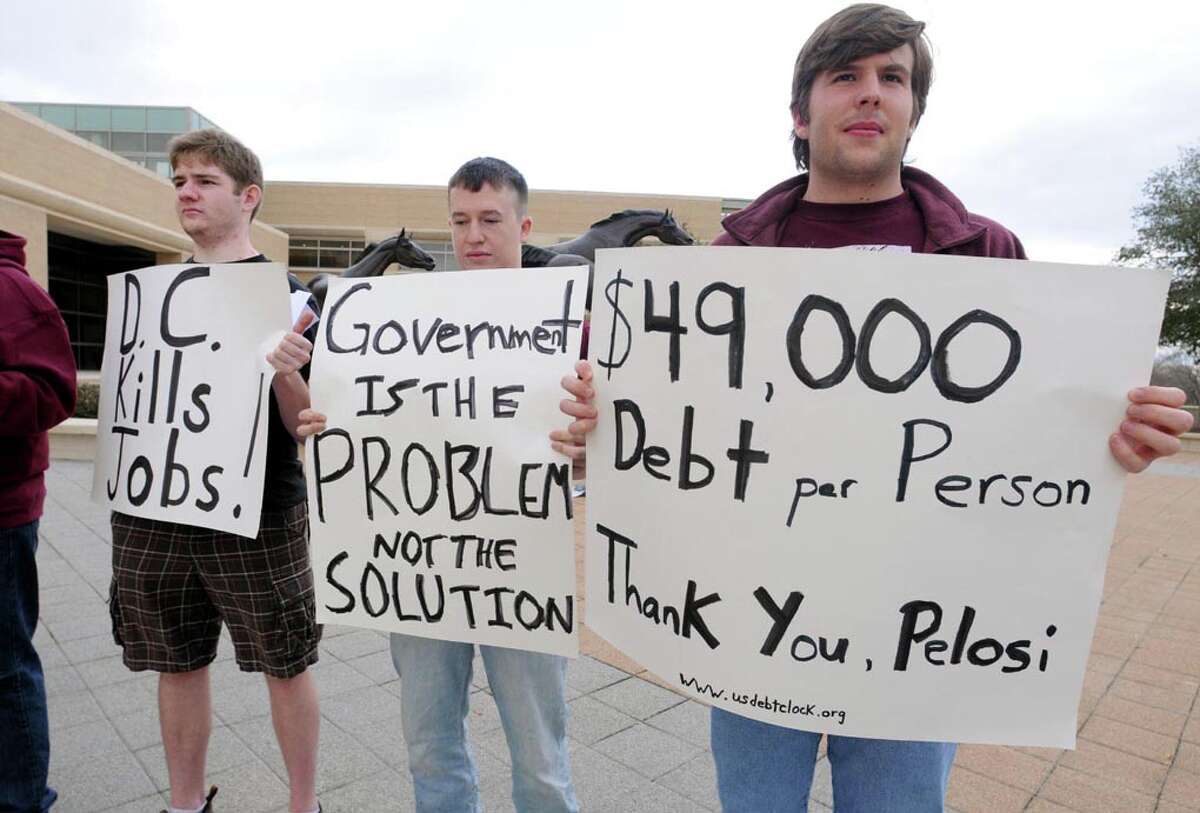 Student demonstrators at Texas A&M University hold signs protesting House Speaker Nancy Pelosi, who visited and spoke at the George H.W. Bush Presidential Library in College Station, Texas, Monday, Feb. 20, 2012. (AP Photo/Bryan-College Station Eagle, Dave McDermand)
