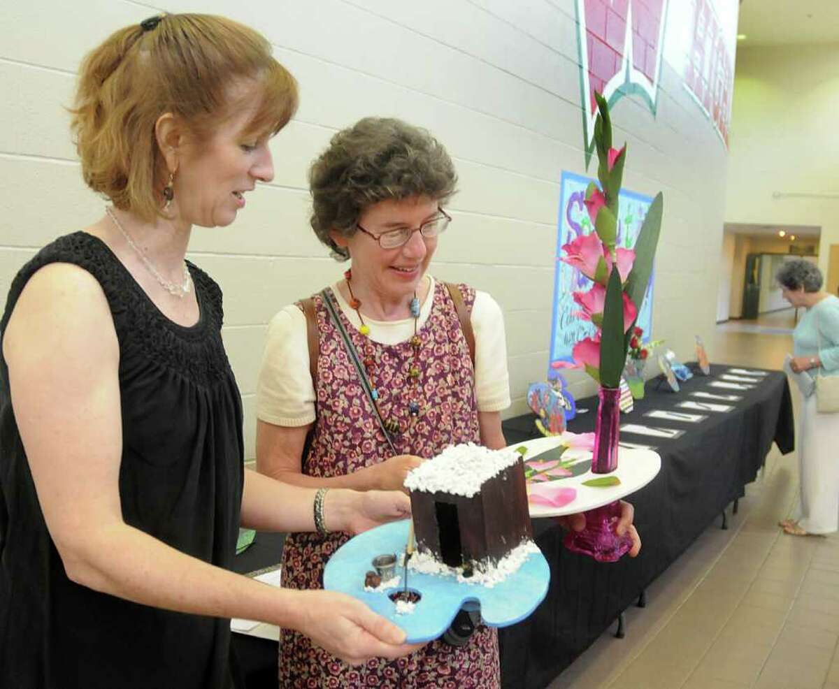 The Woodlands High School teachers Laura Landsbaum and Kathryn Borchers admire two of the palette art pieces on display during The Woodlands High School Palettes & Paintings fundraiser held in May at the high school.