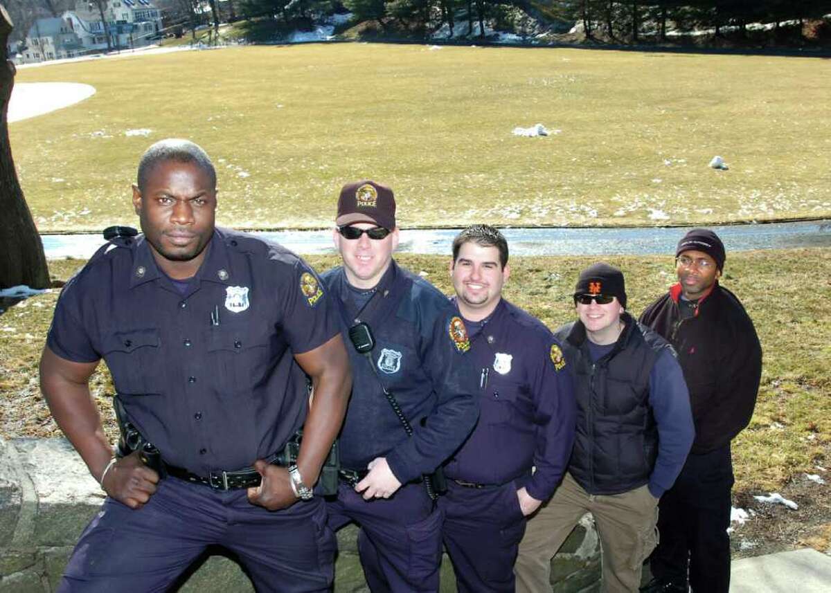 Greenwich police officer Donnell Fludd, left, was charged Monday with second-degree stalking, second-degree harassment and disorderly conduct after the department received a complaint from a woman Fludd was formerly dating. Fludd, one of the co-founders of the department's youth flag football league, is pictured in 2007 with other officers involved in organizing the league. PHOTO/BOB LUCKEY