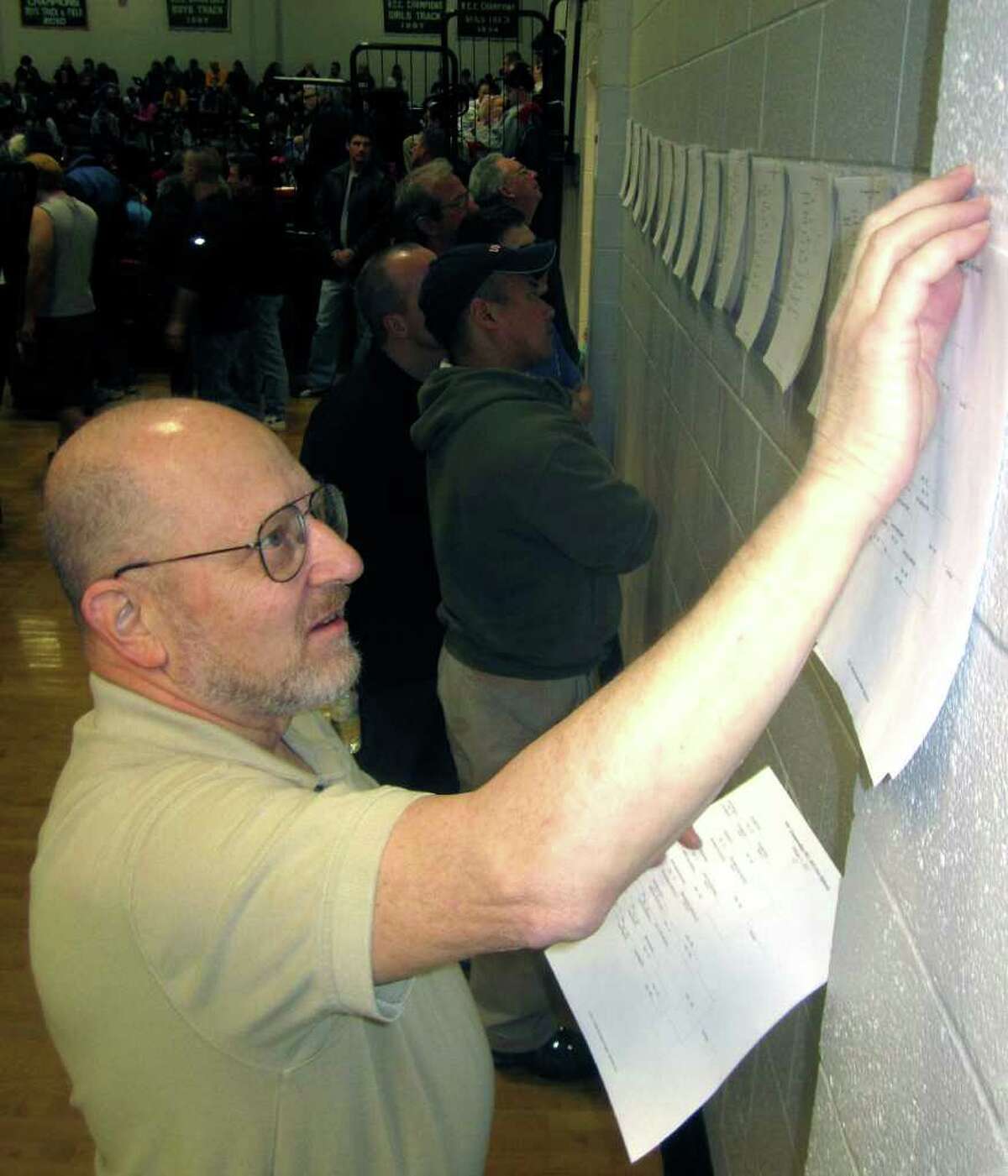 SPECTRUM/Dr. Erich Doubek, the historian and statistician for New Milford High School wrestling, keeps busy creating and posting updates during the South-West Conference tournament at NMHS. Feb. 12, 2012