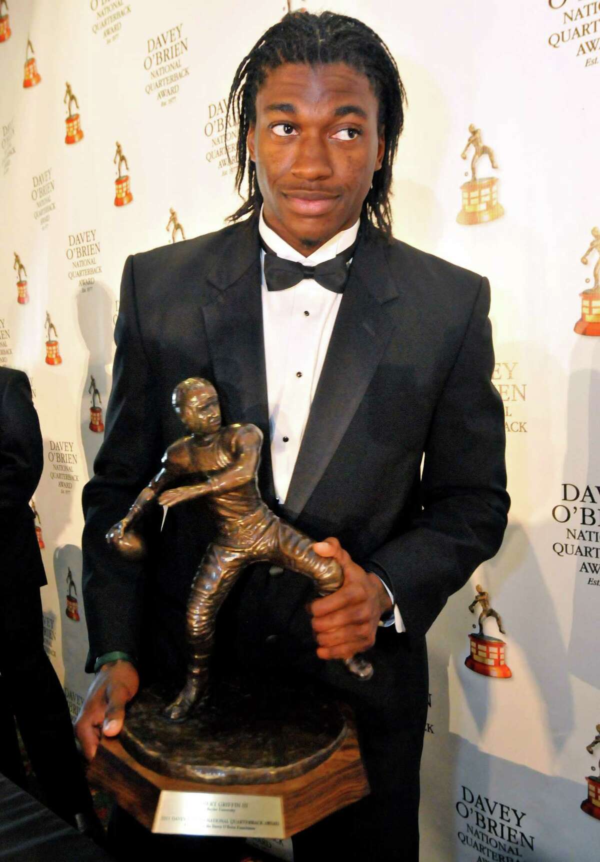 Former Baylor quarterback Robert Griffin III stands with the Davey O'Brien Award, given to the nation's top collegiate quarterback, during a news conference at the awards dinner in Fort Worth, Texas, Monday, Feb. 20, 2012. (AP Photo/Fort Worth Star-Telegram, Max Faulkner) MAGS OUT