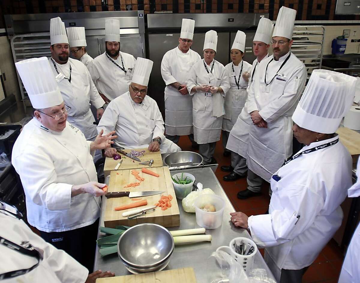 Chef John DeShetler, left, speaks to members of the Wounded Warrior Project taking part in a culinary bootcamp at the Culinary Institute of America in Hyde Park, N.Y., on Wednesday, Feb. 15, 2012. (AP Photo/Mike Groll)