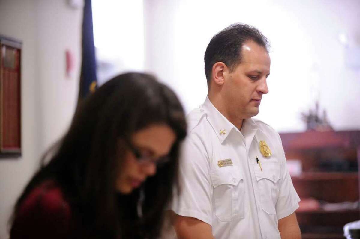 Rachel Ehrlich Albanese, left, of the fire safety group Ctmomsonline, and Greenwich Deputy Fire Marshal, Rob Natale, bow their heads during a moment of remembrance for the Badger family of Stamford that suffered a fire-related tragedy on Christmas Day during a fire safety event at the Glenville Fire Station, Saturday, Feb. 25, 2012.