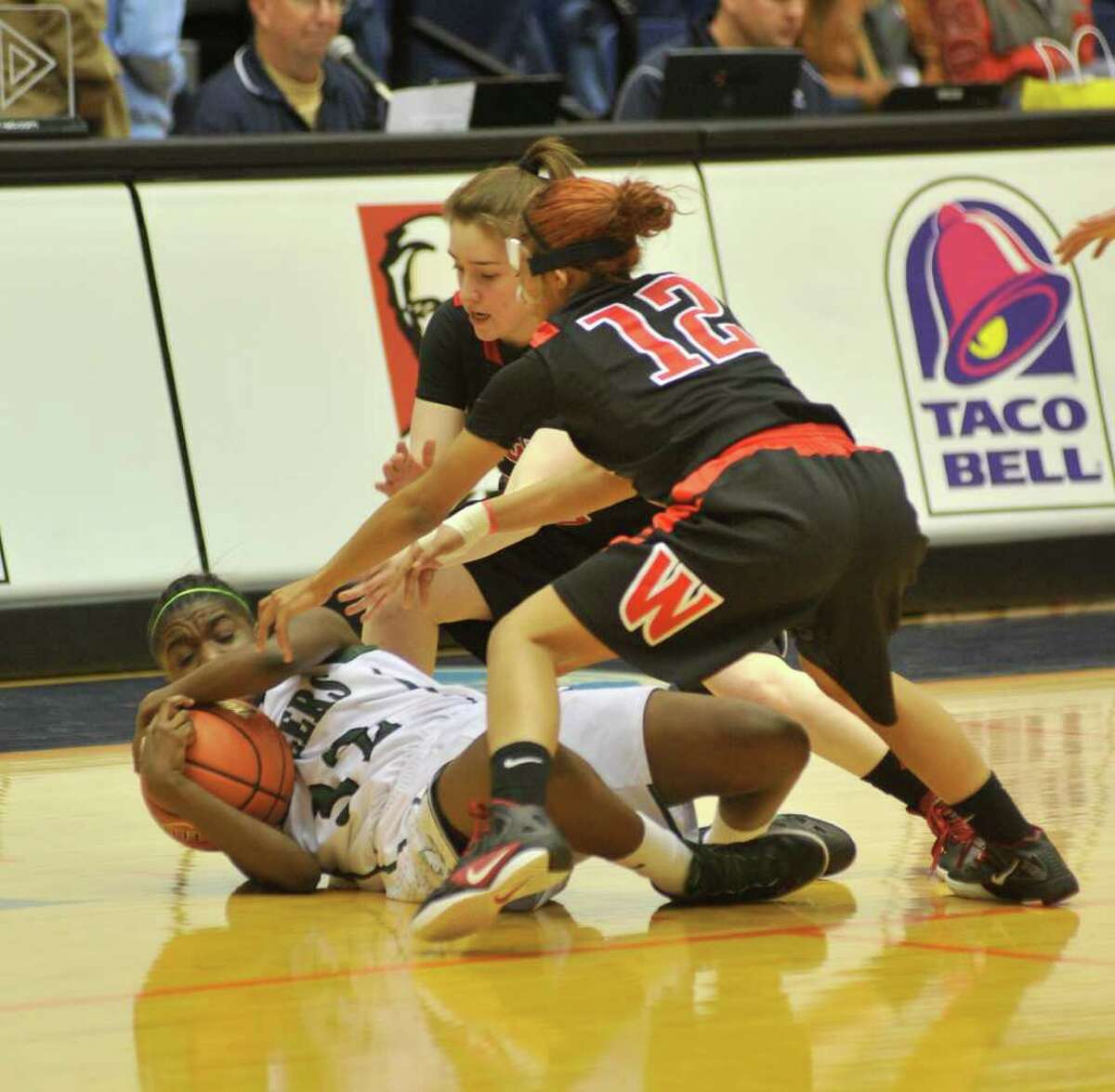 Reagan's Moriah Mack controls a loose ball as Wagner's Corrina Moncada and Aundrea Davis try to steal it during the Region IV-5A final on Saturday, Feb. 25, 2012, at UTSA.