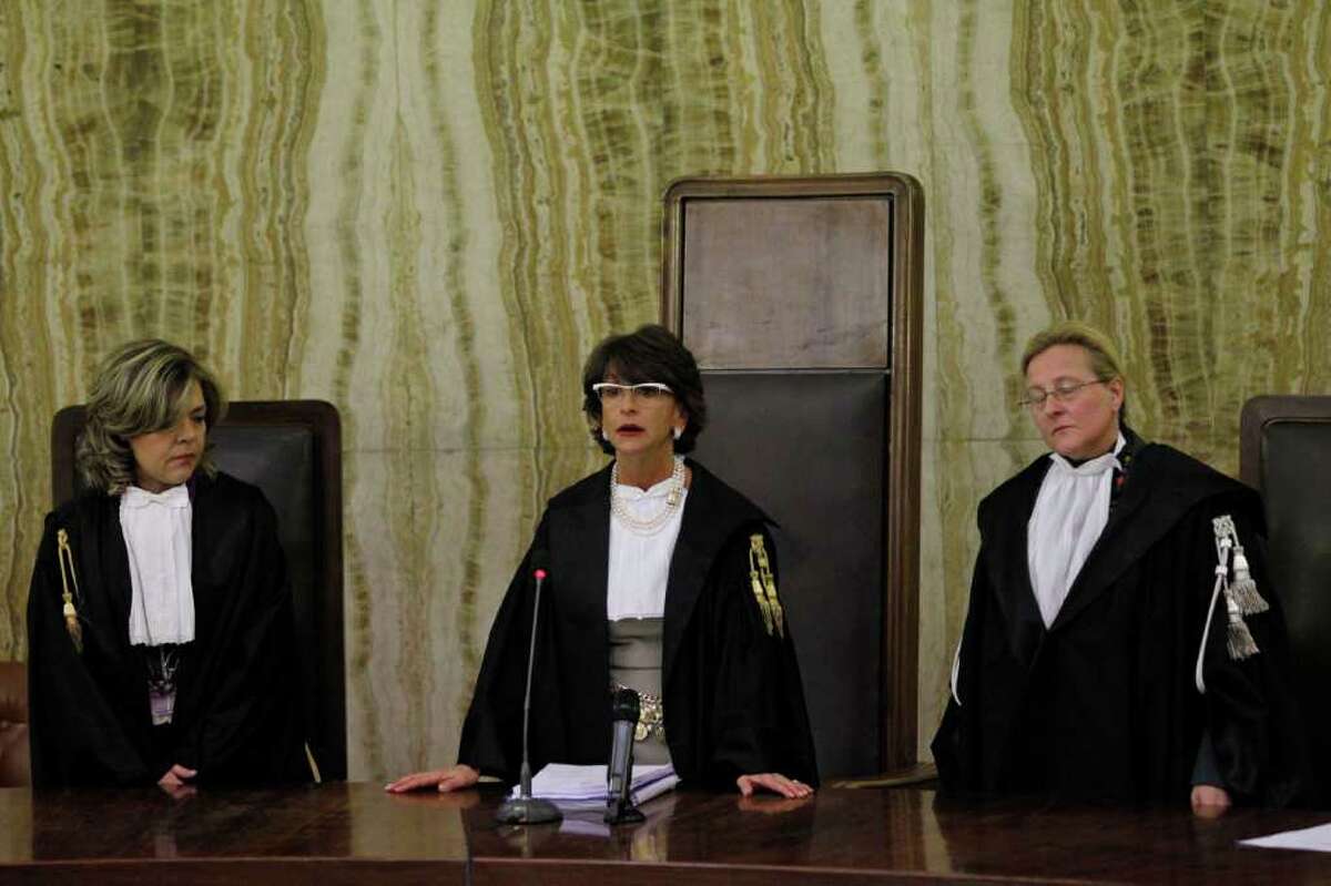Chief judge of the court Francesca Vitale, center, reads the verdict in a case where former Italian Prime Minister Silvio Berlusconi stands accused of bribing a British lawyer David Mills in Milan, Italy, Saturday, Feb. 25, 2012. A Milan court Saturday threw out the corruption trial against Silvio Berlusconi, ruling that the statute of limitations has run out on the case and essentially handing Italy's former premier another victory in a long string of judicial woes he has faced. (AP Photo/Luca Bruno)