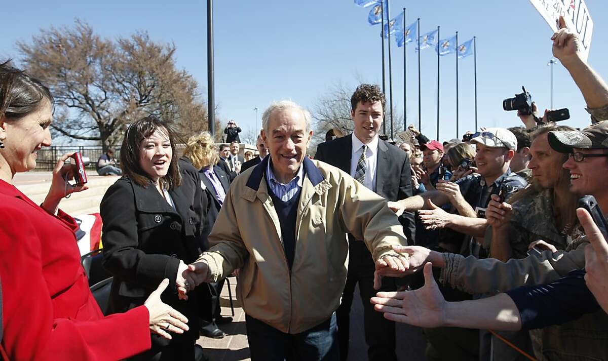 Republican presidential candidate Rep. Ron Paul, R-Texas, shakes hands as he arrives at a rally in Oklahoma City, Saturday, Feb. 25, 2012. (AP Photo/Sue Ogrocki)