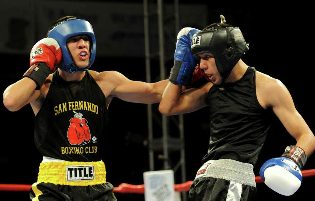 Kendo Castaneda (left) tries to land a punch to the head of Christian Santibanes (right) during the open 132-pound lightweight bout at the San Antonio Regional Golden Gloves Championship at the Scottish Rite Cathedral on Saturday, Feb. 25, 2012.