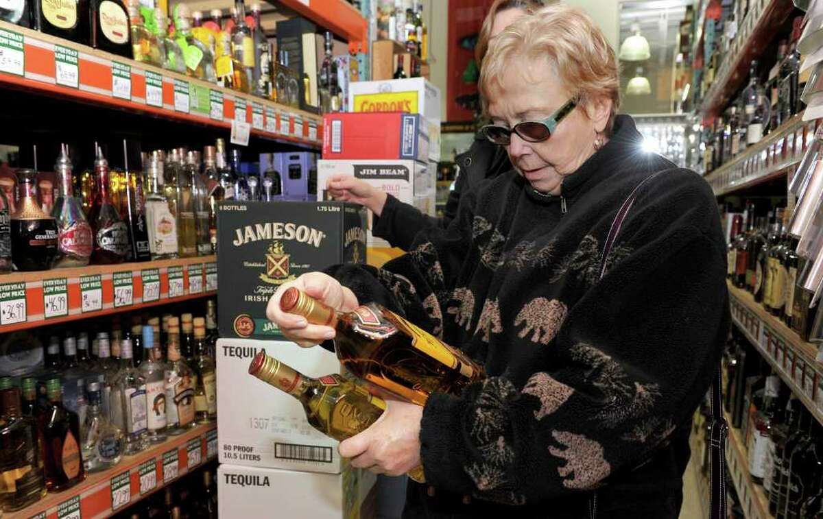 Lee Williams of Ossining, N.Y., selects liquor Tuesday at Warehouse Wines & Liquor on Mill Plain Road in Danbury. The state's350-year ban selling liquor on Sundays may fall this year. Photo taken Tuesday, Feb. 28, 2012.