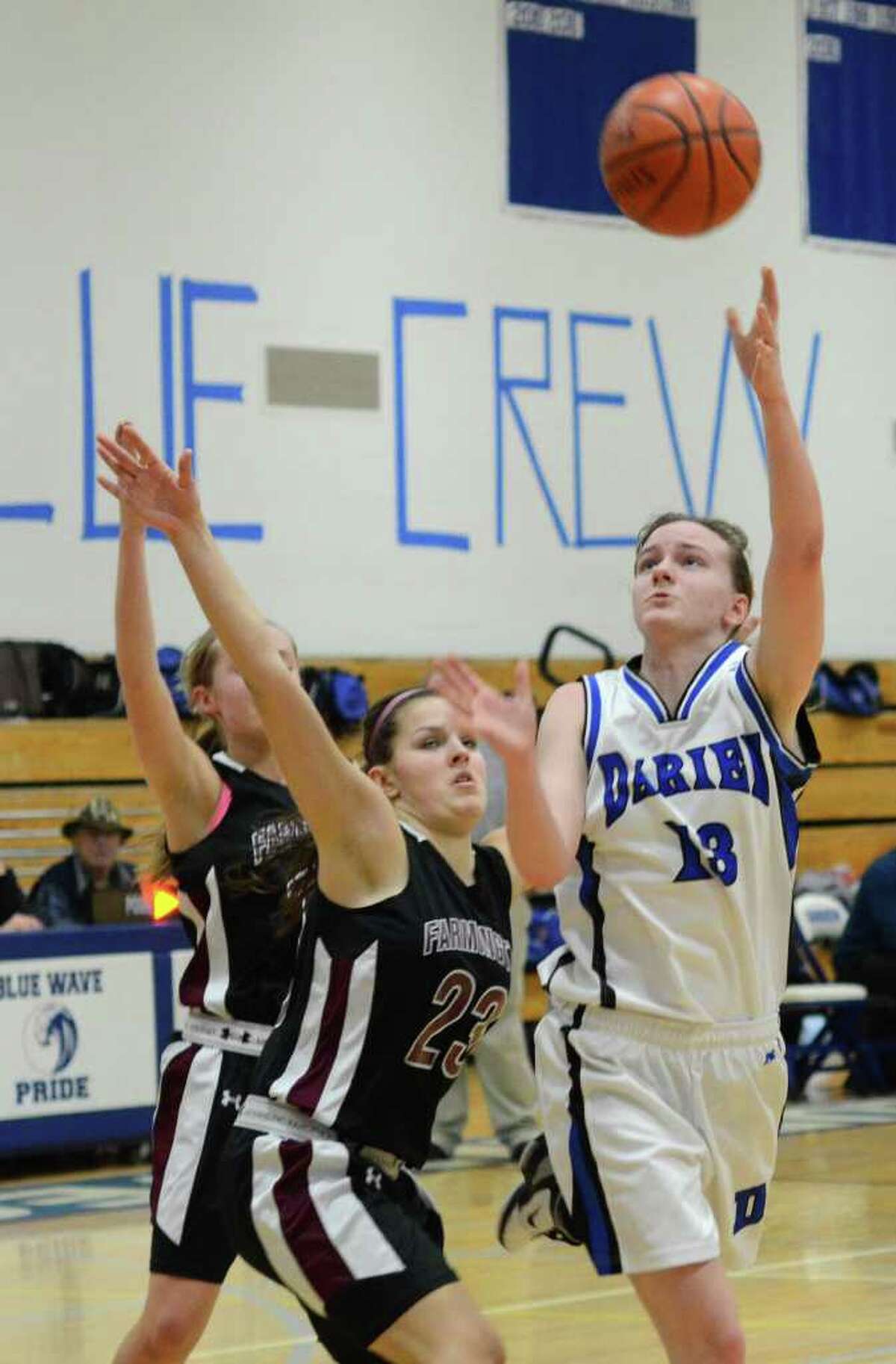 Darien's Kate Bushell (13) goes up for a shot against Farmington's Ugne Vaiciulyte (23) during the girls basketball game at Darien High School on Tuesday, Feb. 28, 2012.