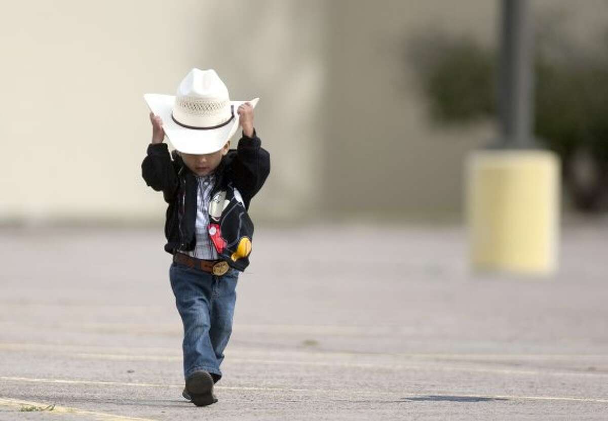 Wearing his Go Texan Day apparel, Adrian Cardona, 3, walks to greet riders with the Spanish Trail Rider's group in the parking lot of a Sears department store on the 4000 block of N. Shepherd, where the riders spent the night before they made their three-hour ride to Memorial Park on Feb. 24, 2012. (Johnny Hanson / Houston Chronicle)