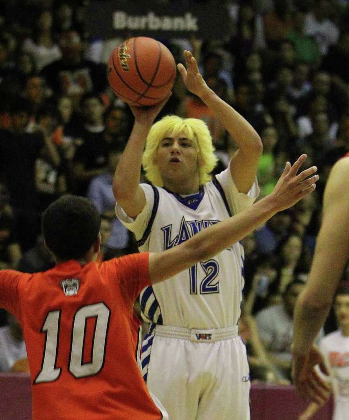 Lanier’s Troy Lopez launches from deep against the efforts of Burbank’s Jason Ainsworth in a Class 4A third-round contest.