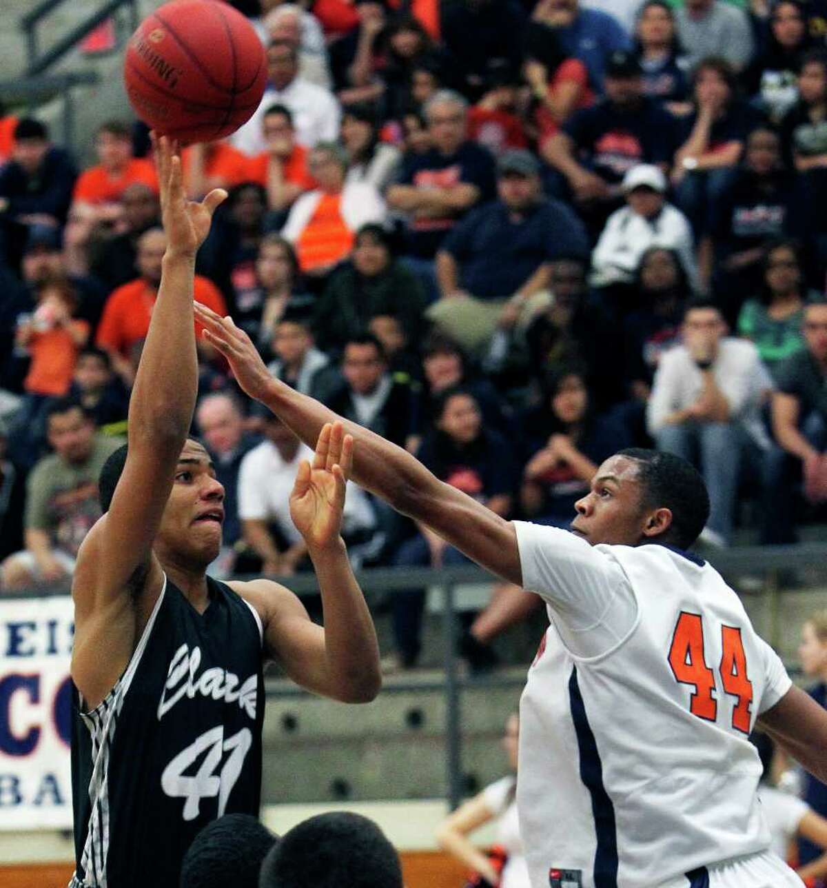 Clark post Shawn Gulley (left) gets off a shot despite the defensive efforts of Eric Robinson of Brandeis during the Class 5A third-round playoff game at Taylor Field House. The Cougars won 45-39.