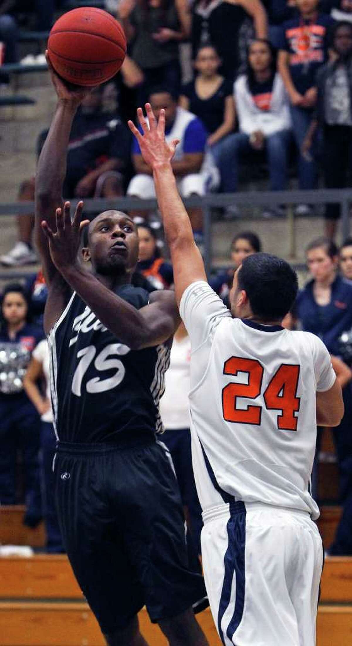 Clark’s Travis Matthews (left) goes with a hook shot over Jeremy Martinez of Brandeis. The forward pitched in with 10 points to spark the Cougars’ comeback.