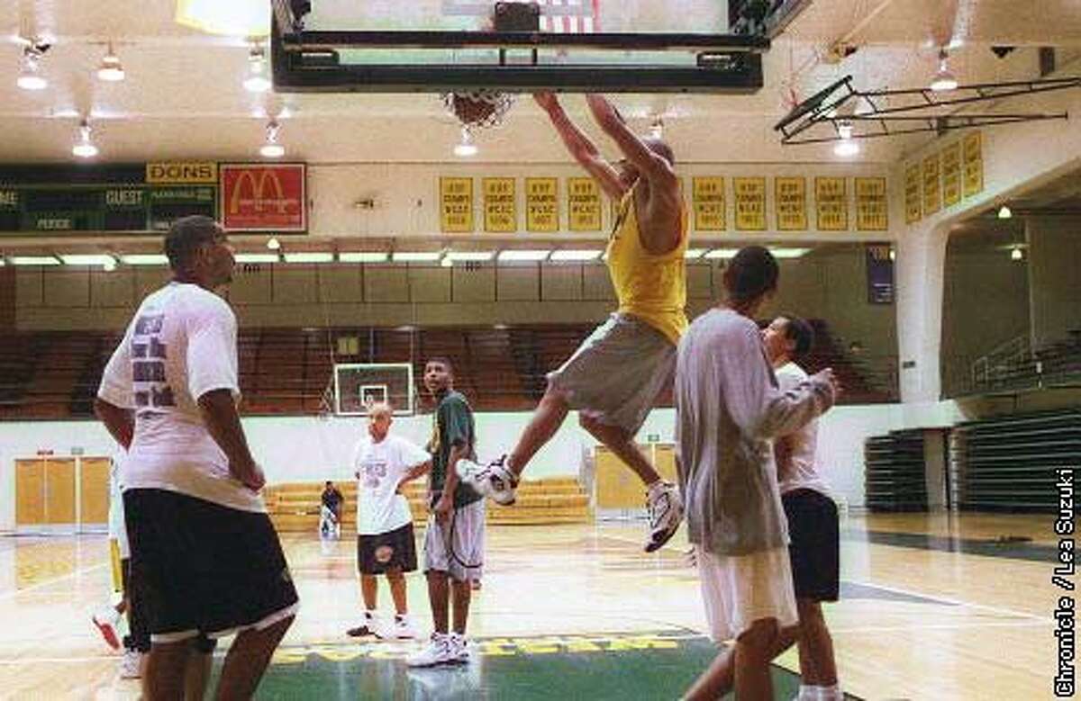 Ali Thomas, sophmore at USF and member of the Men's basketball team, does a slam dunk in Memorial Gym at USF during open gym. Photo by Lea Suzuki