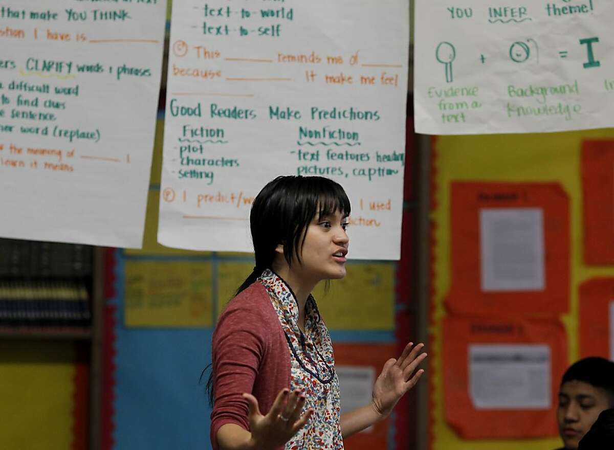 Beneath banners of notes, teacher Kat Florita discusses an upcoming lesson. Kat Florita teaches an 8th grade language arts class at Everett Middle School in San Francisco, Calif. She is one of the first year teachers who will not get a layoff notice because she is in the Superintendent's Zone, a specially skilled and trained instructor.