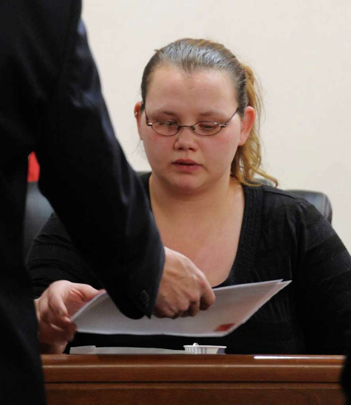Loretta Colegrove looks over some of the evidence while on the stand during the trial of Matthew Slocum, her boyfriend, in Washington County Court in Fort Edward, N.Y. March 1, 2012. Slocum is accused of killing three people in White Creek last year and Colegrove testified that she saw him kill one of the people. (Skip Dickstein / Times Union)