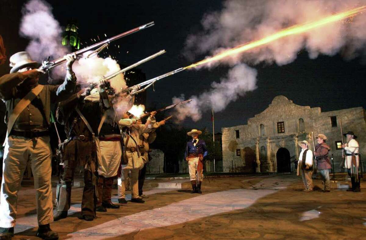 Re-enactors fire rifles at the Alamo in San Antonio during a "Dawn at the Alamo" ceremony.
