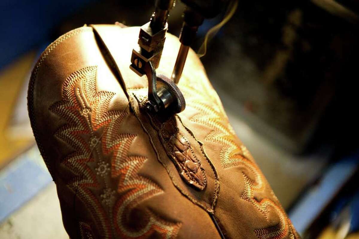 Antonio Garcia installs the pull tabs on a pair of boots with a sewing machine Wednesday, Feb. 9, 2011, in the Lucchese Boot Company factory in El Paso. Garcia, who's been with Lucchese for 23-years says he's made boots his entire life and hopes to retire as a boot maker. ( Nick de la Torre / Houston Chronicle )