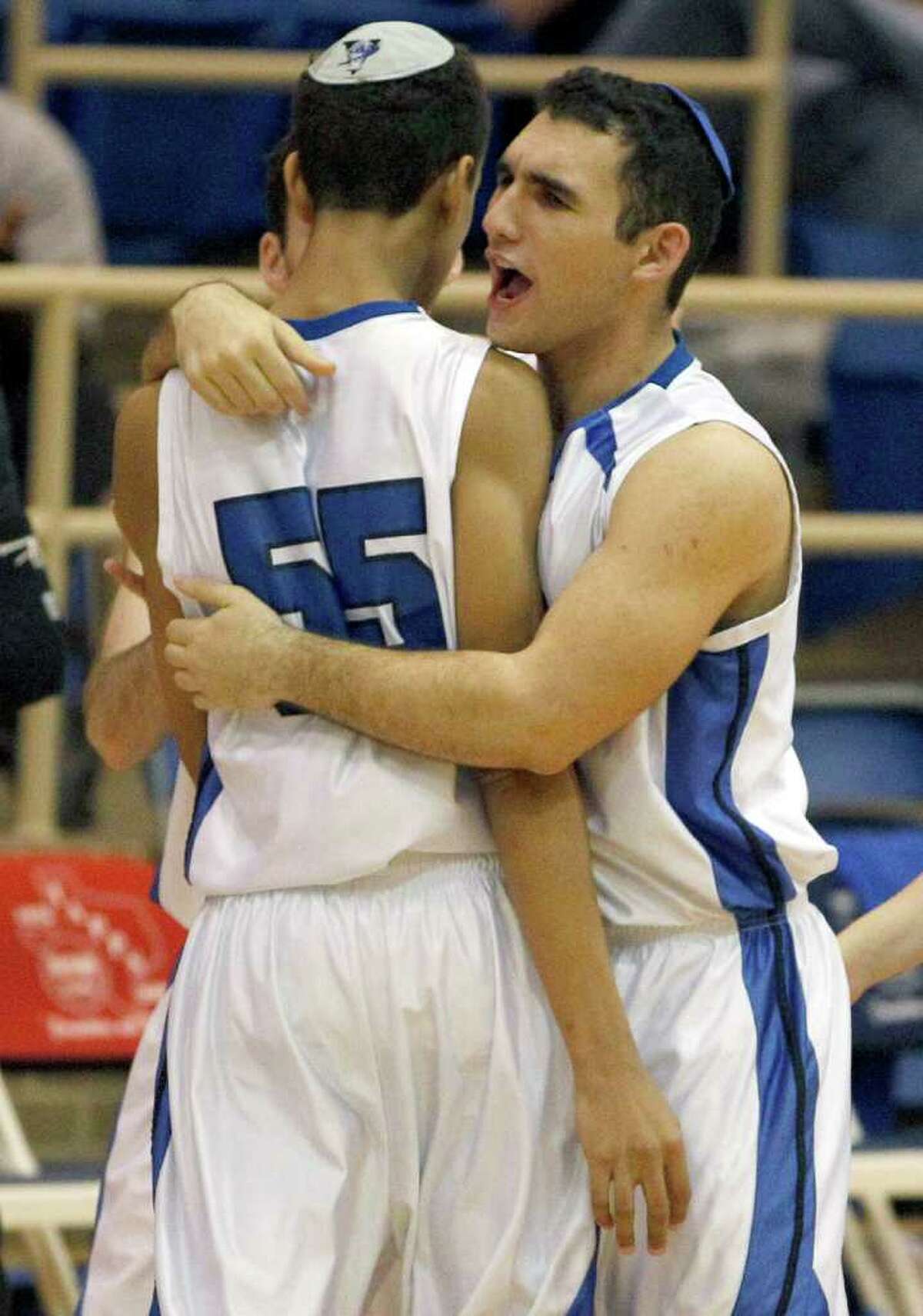 Beren Academy's Aaron Hakakian, right, hugs teammate Drayton Ratcliff (55) during the first half of a high school basketball game against Dallas Covenant in Fort Worth, Texas on Friday, March 2, 2012. The Orthodox Jewish school played an afternoon playoff game that was rescheduled so it doesn't conflict with the Sabbath. The Texas Association of Private and Parochial Schools made the change after first rejecting appeals from Beren Academy to move the game. Beren won 58-46.