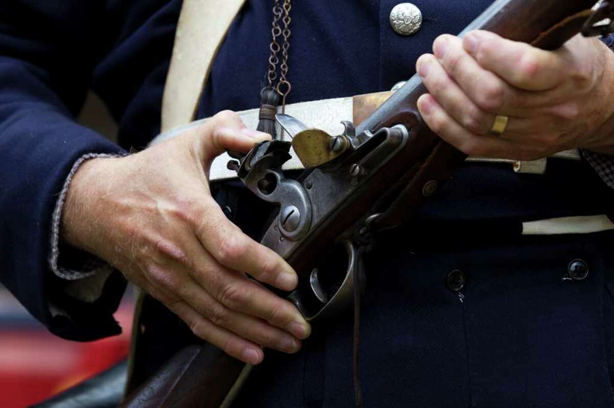 Tom Whitesides prepares to fire his weapon as members of the Texas Army commemorate Texas Independence Day at the 1823 Old Place cabin at Sam Houston Park.