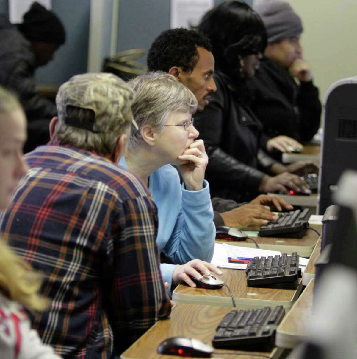 The unemployed use computers to search for jobs at a Virginia Employment Commission office in Mechanicsville. The jobless rate is dipping, but millions are still out of work. And that could have tax implications.