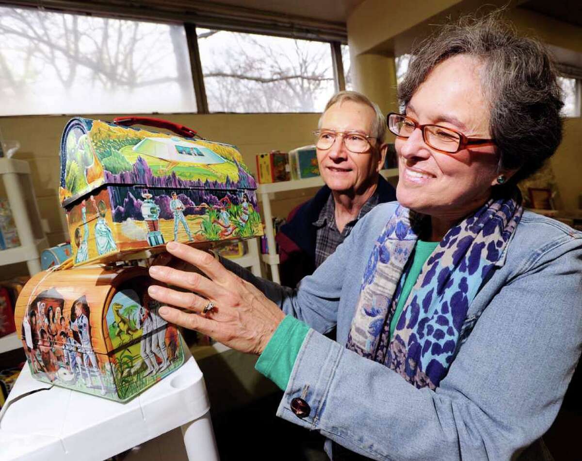 At right, Susan Taplin of Glenville points to the robot on a 1960s Lost In Space lunch box during the American antique toy and coin-op show at the Eastern Greenwich Civic Center, Saturday, March 3, 2012. Taplin said her cousin, Richard Tufeld, was the voice talent for the robot that was known for the famous catchphrase "Danger, Will Robinson!" At left is Taplin's husband, Gary.