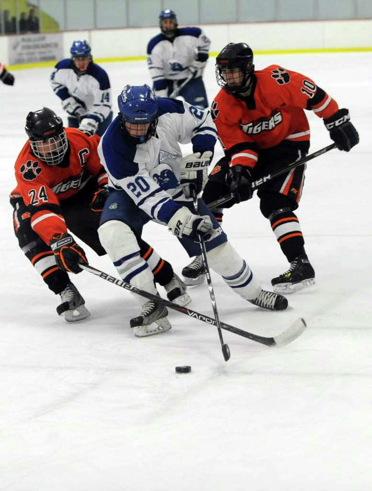 Darien's Trent Bergin, center, controls the puck as he is surrounded by Ridgefield's Brendan Bossidy, left, and Henry Gough, right, during Saturday's FCIAC Teir I Boys Hockey Championship at Terry Conners Rink in Stamford on March 3, 2012.