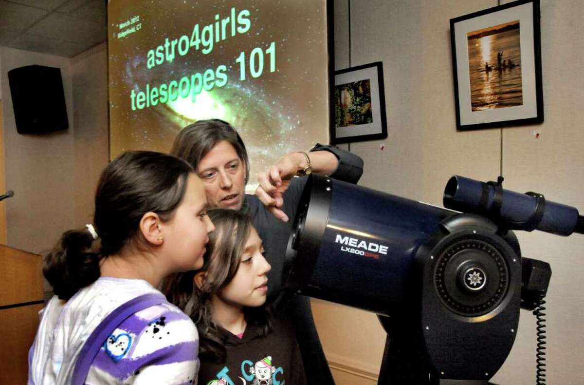 Planatary astronomer Heidi Hammel talks about telescopes with Gillian Stone, 11, left, and Makenzi Macko, 10, during a program at the Ridgefield Library Saturday, March 3, 2012. Both girls are part of the Astro 4 Girls project.
