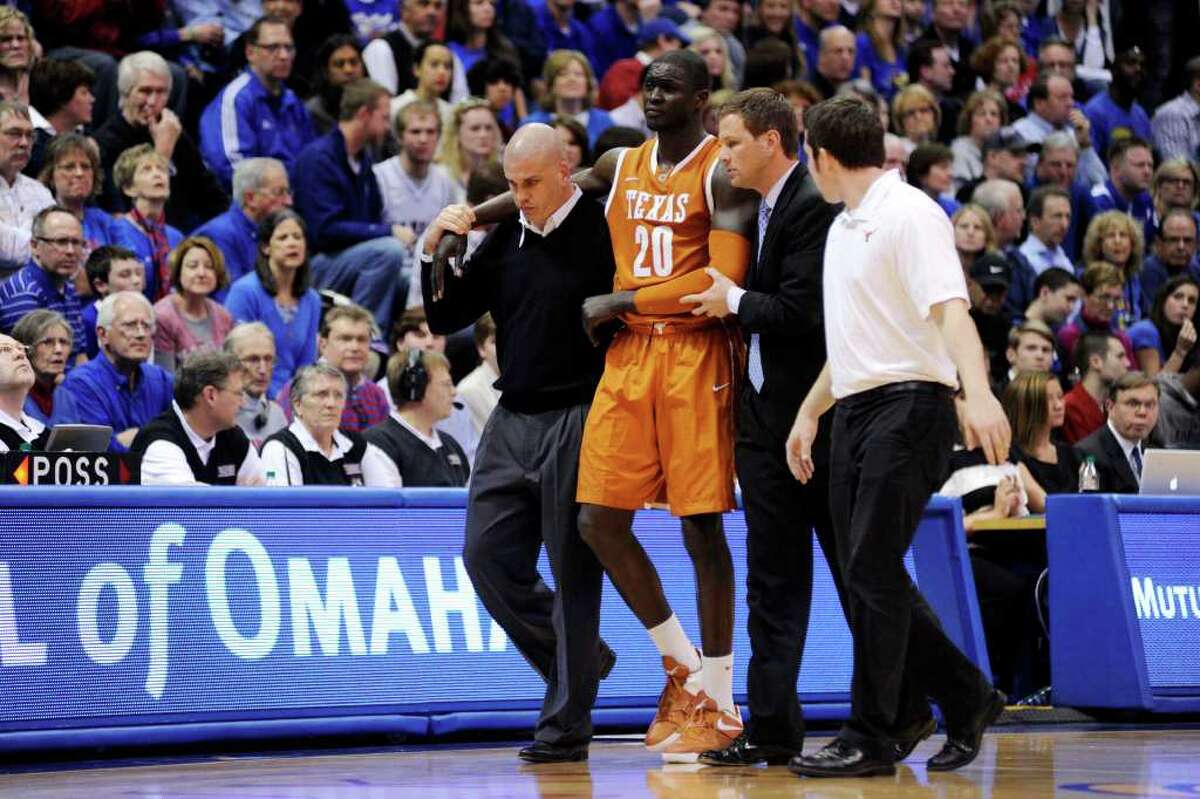 Texas' Alexis Wangmene (20) is helped off the court after being injured in the second half of an NCAA college basketball game against Kansas, Saturday, March 3, 2012, in Lawrence, Kan. Kansas won 73-63.